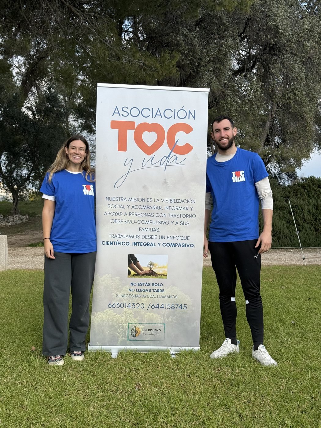 Equipo de TOC y Vida junto al roll-up de la asociación